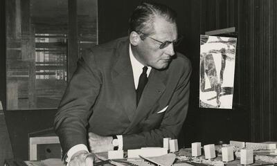 Léon Stynen gebogen over de maquette van de Wezenbergsite in Antwerpen, ca.1962.