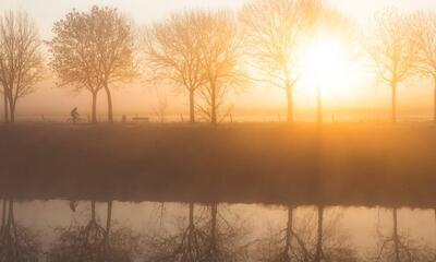 Fietser langs de rivier Leie tijdens een mistige ochtend in de winter met prachtige zonsopkomst in M van Fotografie Krist / Top Foto Vlaanderen 