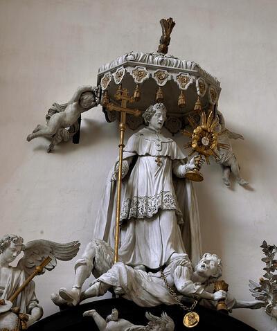 Helemaal bovenaan staat Norbertus onder een baldakijn, hij plaatst zijn voeten op het lichaam van de ketter Tanchelmus en houdt een monstrans met hostie in de hand, om de aanwezigheid van Christus in de eucharistie te benadrukken