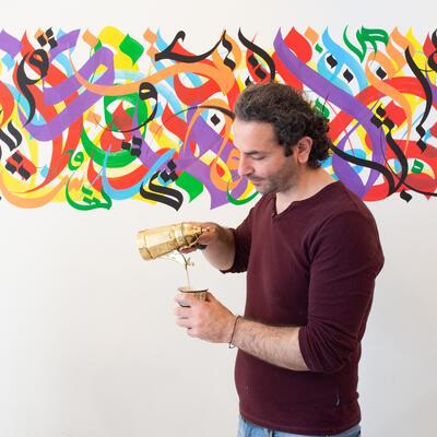Saddam Shkair schenkt koffie uit zoals dat voor gasten gebruikelijk is