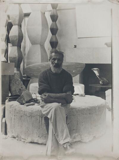 Constantin Brancusi in zijn atelier (ca. 1934) met op de achtergrond Eindeloze Zuilen I tot IV, De vis en Leda