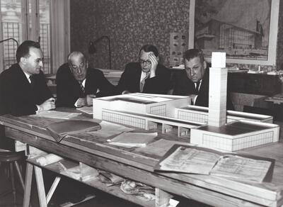 Jan-Albert Goris (links), Henry Van de Velde (tweede van links), Léon Stynen (tweede van rechts) en Paul Celis (rechts), gebogen over de maquette van het Belgisch paviljoen voor de wereldtentoonstelling van New York in 1939, foto uit 1937.