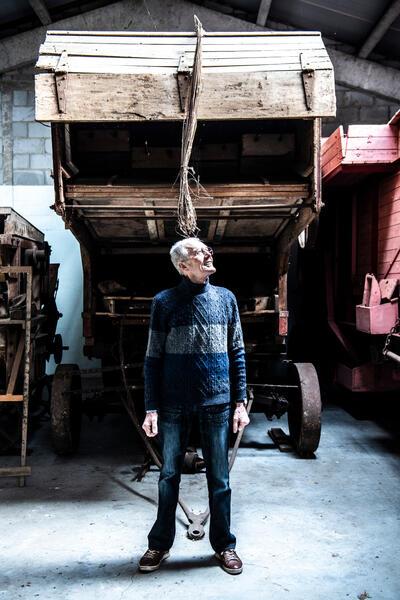 Frans D’Haeyere bij zijn persoonlijk ‘topstuk’: de maaidorser van Claeys van net na de Tweede Wereldoorlog Foto: Saskia Vanderstichele