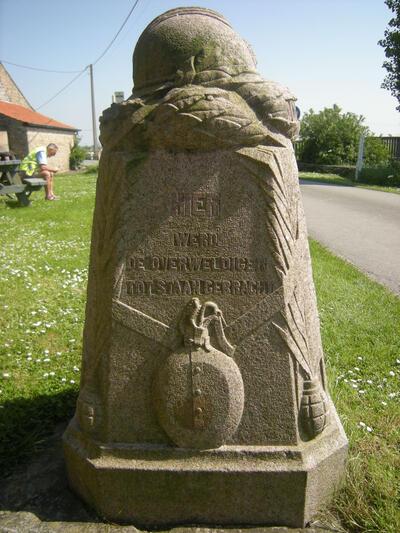 Demarcatiepaal nr. 11 in Stuivekenskerke met het opschrift in het Nederlands, Frans en Engels dat hier de overweldiger tot staan werd gebracht, roze graniet, hoogte 1,25 cm