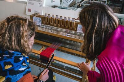 Demonstraties aan de handmatige en machinale weefgetouwen.