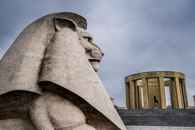 Julien De Ridder (architect) en Karel Aubroeck (beeldhouwer van het ruiterstandbeeld en de allegorische voorstellingen in bas-reliëf), monument als hulde aan alle Belgische frontsoldaten en hun aanvoerder, de koning-ridder, Kustweg (Sluizencomplex De Ganzepoot), Nieuwpoort, inhuldiging 24 juli 1938 (op de voorgrond een detail van het Britse Nieuport Memorial)