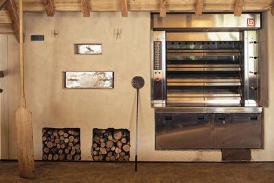 / De broden worden gebakken in een traditionele houtoven en in een hightech oven