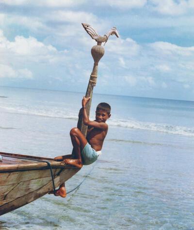 Europalia, Jongen van Aru op de achtersteven van een boot met een familie-embleem: een houten haanfiguur die een mythische stamvader voorstelt Foto: Antoon Egging (omstreeks 1980)