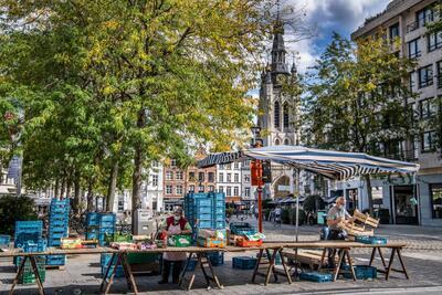 De sierlijke toren van de Sint-Maartenskerk in Kortrijk rijst hoog boven het commerciële gewoel