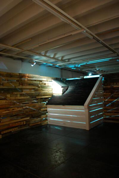Jonas Vansteenkiste, A Space of Conﬁnement, 2011, installatie, hout, licht, tapijt,  zetel en gordijnen, 