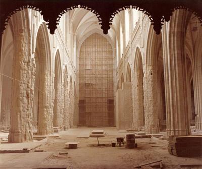 De restauratie van het schip in 1976. De zuilen werden ontdaan van het gipspakket en vertonen de schade van de brand in 1533. Bemerk rechts de gerestaureerde proefpijler en achteraan de scheidingswand tussen koor en schip. Antwerpen, Architectuurarchief Provincie Antwerpen, onze-lieve-vrouwekathedraal
