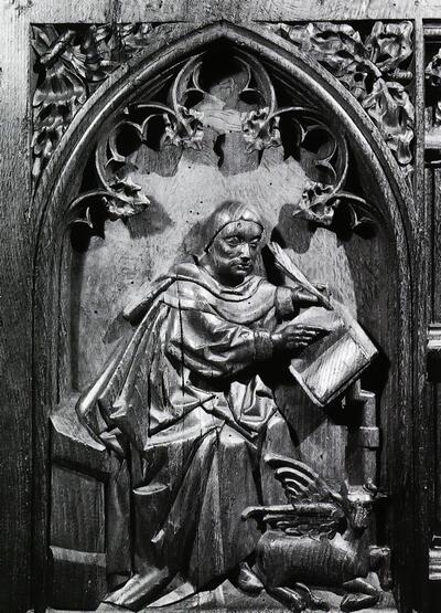De evangelist Lucas, met zijn symbool, het gevleugeld rund Koorgestoelte van de SintSalvatorskathedraal van Brugge. Laat-gotiek