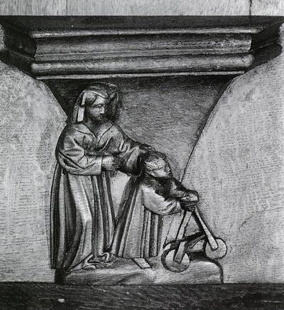 Vrouw en kindje met loopstoel. Zitterke of misericorde van het koorgestoelte van de Sint­Salvatorskathedraal van Brugge. Laat-gotiek