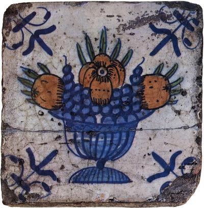 Polychrome tegel van faïence met voorstelling van vruchtenschaal. Keramiek