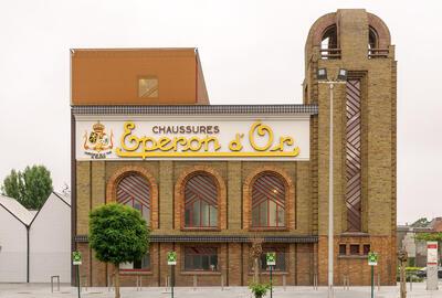 Izegem, De gerestaureerde schoenfabriek met in de gevelfries het opschrift Eperon d’Or en de wapenschilden van België en Luxemburg in ververst bladgoud