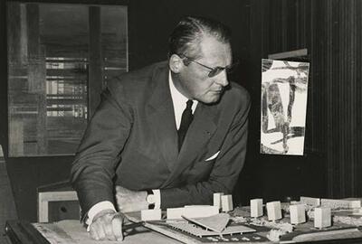 Léon Stynen gebogen over de maquette van de Wezenbergsite in Antwerpen, ca.1962.