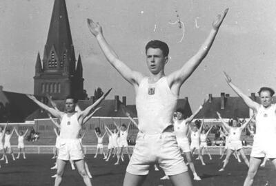 Turnfeest in het stadion van FC Beringen, op de achtergrond de Sint-Theodarduskerk van Beringen-Mijn, Archief Mijnmuseum.